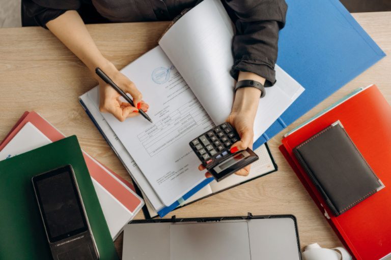 A founder reviewing invoices with a calculator